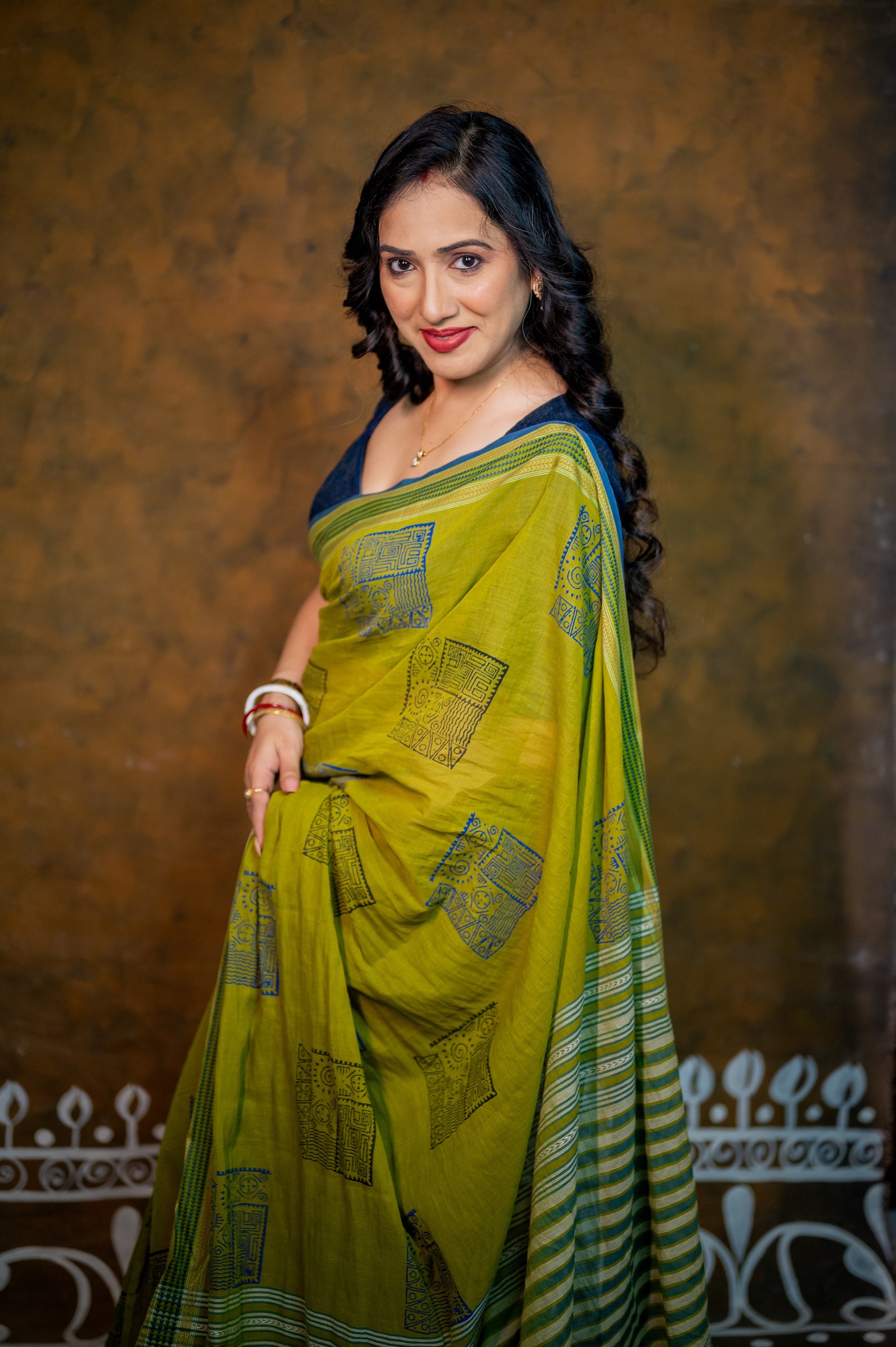Woman flaunting front view of blue jamebar blouse with statement neckline and contrasting saree.