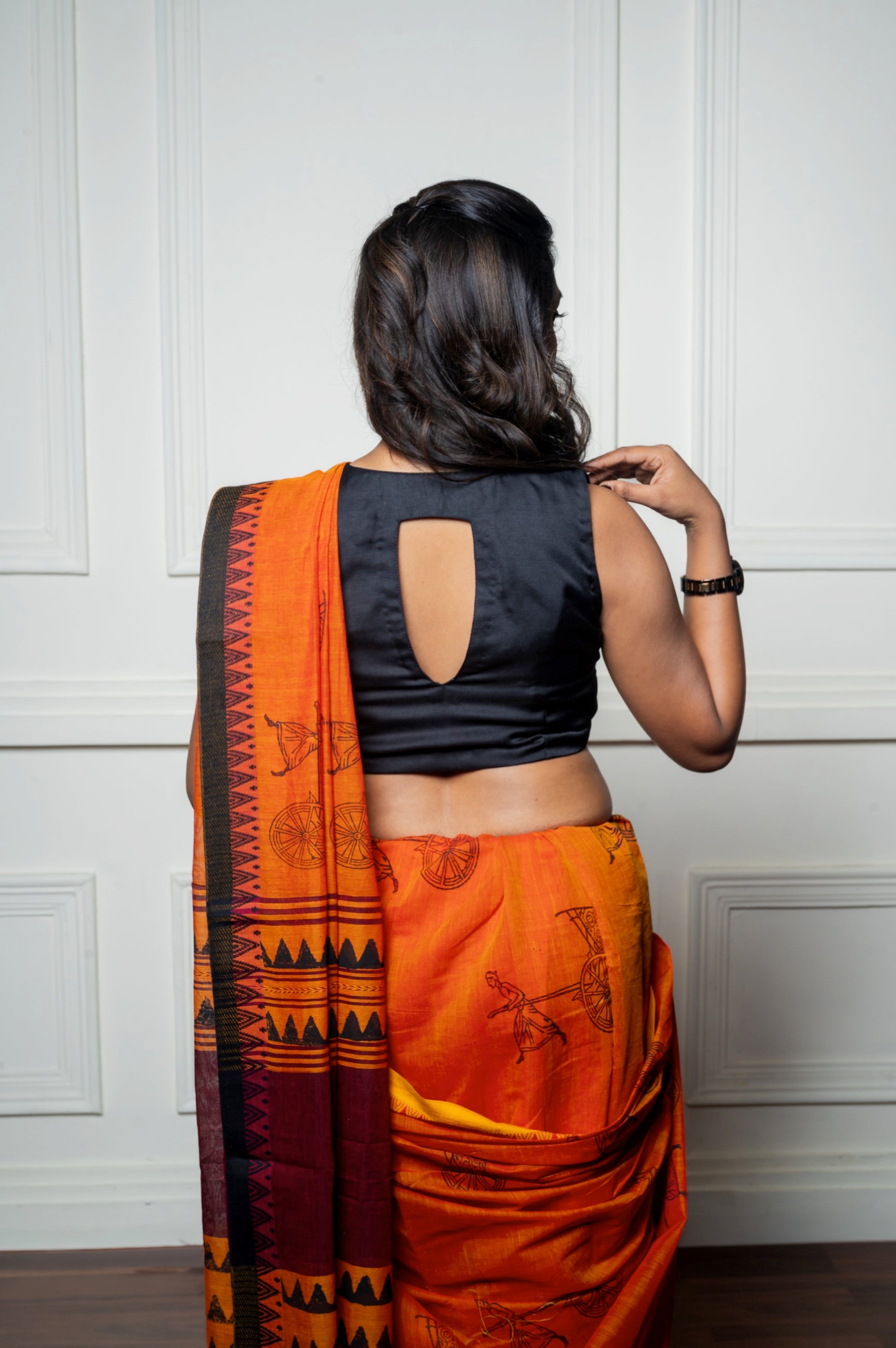 Rear view of the black blouse featuring a deep cut-out back design, highlighting the modern silhouette.