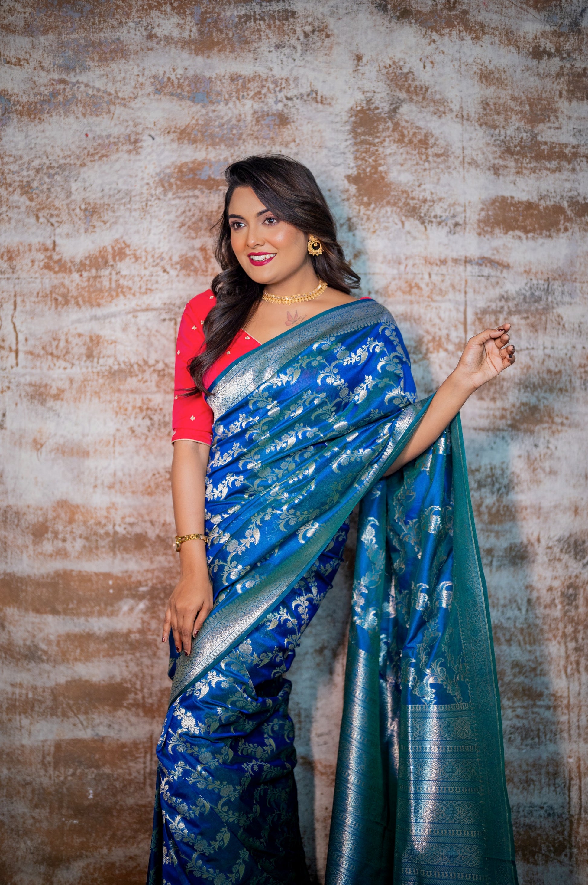 Close-up of woman wearing pearl and zardozi embroidered rani pink blouse and blue silk saree